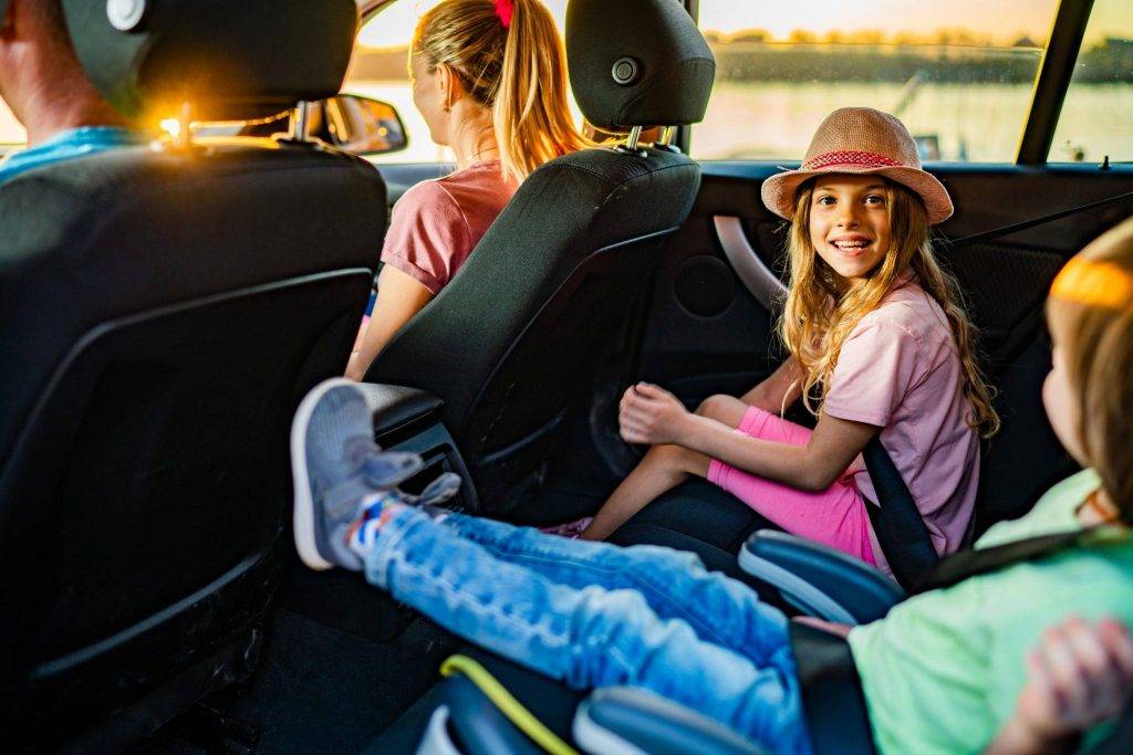 Cute little girl traveling in car with family
